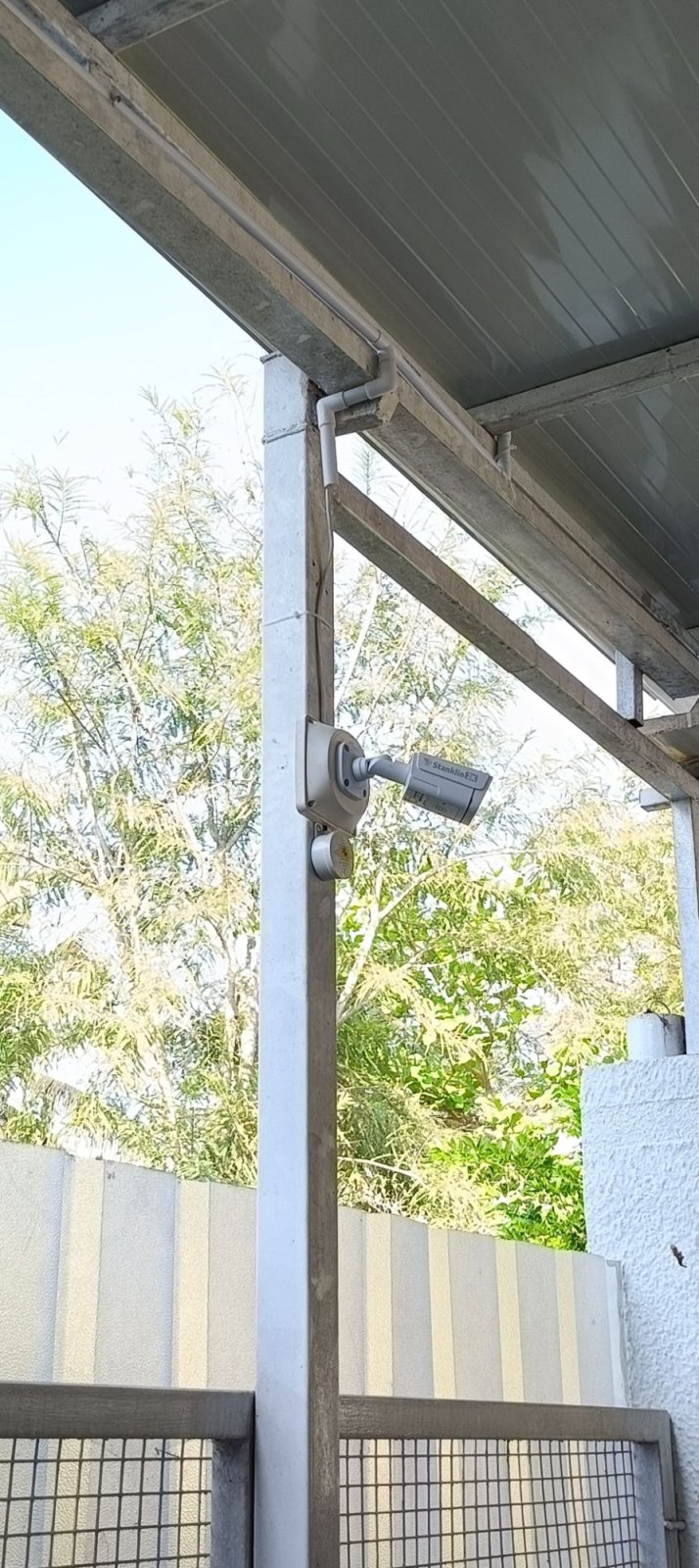 Stanklin outdoor bullet camera on a bracket under a roof overhang with cable in conduit