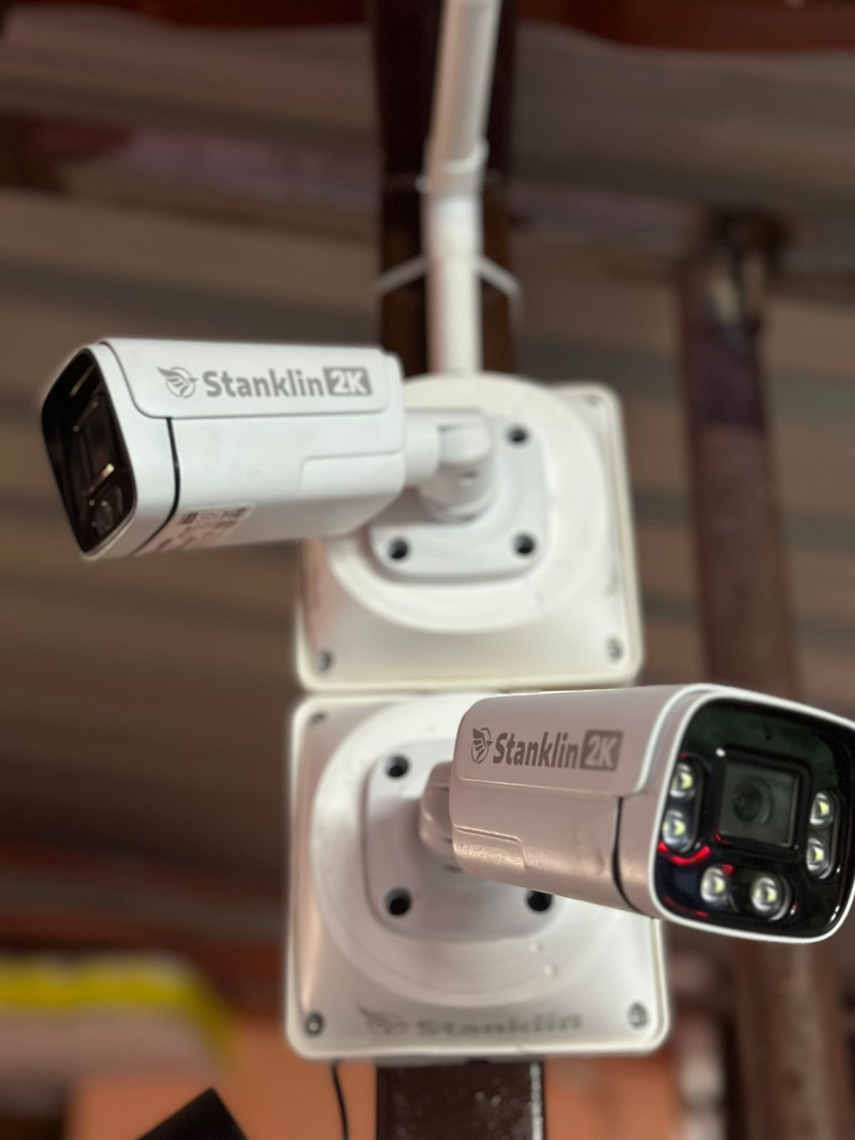 Two Stanklin 2K bullet cameras with white light LEDs on white wall mounts